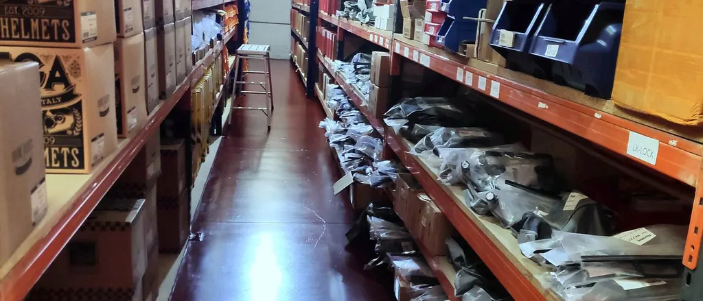 Picking aisle with labelled locations, helmet boxes and parts bagged by reference
